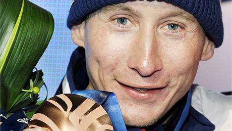 Luká� Bauer stojí s bronzovou medailí po závod� na 15 km volnou technikou. (15. února 2010)