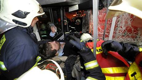 Záchranái a hasii vyproují poranného idie z autobusu, který havaroval ráno na erném Most (16. února 2010)