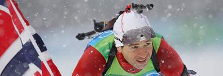 Ole Einar Björndalen se s norskou vlajkou v ruce raduje ze zlaté medaile, kterou vybojoval spolu se svými týmovými kolegy ve tafetovém závod biatlonist.