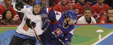 Ville Peltonen z Finska atakuje slovenského hokejistu Andreje Sekeru v zápase o tetí místo na ZOH ve Vancouveru.