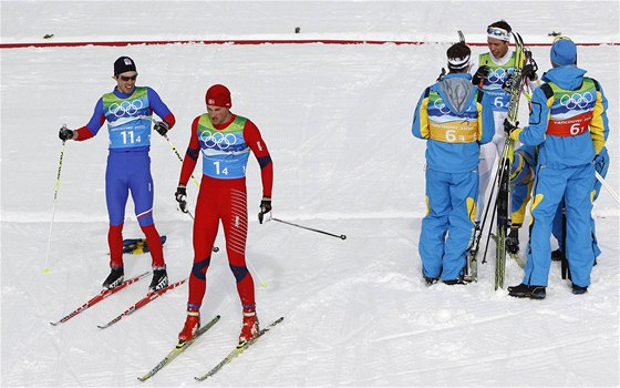 eský závodník Martin Koukal (vlevo) vedle Pettera Northuga z Norska v cíli olympijského závodu tafet. Zlatou medaili slaví védové (vpravo)