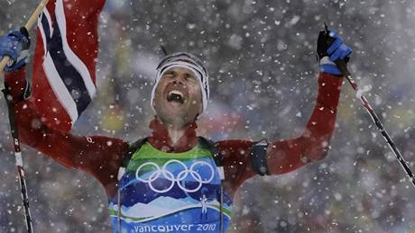 DALŠÍ ZLATO PRO LEGENDU. Finišman norské štafety biatlonistů, Ole Einar Björndalen, se s vlajkou v ruce raduje z vítězství. Získal tak již své šesté olympijské zlato.