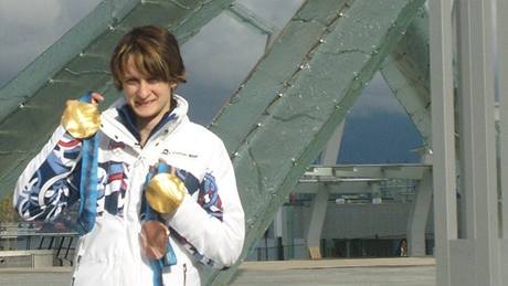 Martina Sáblíková pózuje s medailemi u olympijského ohn. 