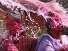 Bhem indického festivalu Holi na sebe lidé stíkají vodu a sypou barevný práek. Svátkem barev, jak se mu také íka, si pipomínají píchod jara. (1. bezna 2010)