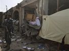 Policista hlídkuje u budovy v Kandaháru, kterou zniil jeden z výbuch. (13. bezna 2010)