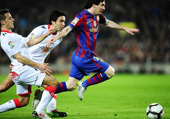 Lionel Messi z Barcelony (vpravo) se snaí uniknout Javieru Camunasovi (vlevo) a Javad Nekoumanovi z Osasuny Pamplona.  