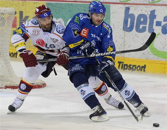 Sparanský hokejista Martin Ruinský se snaí dostat k puku pes vítkovického Vladimíra Siáka.