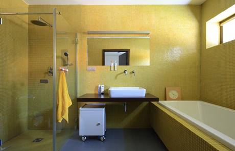 Stdm design koupelny rodi je zaloen na kontrastu velkoformtov dlaby a jemn mozaiky, ed a lut barvy