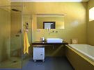 Stídmý design koupelny rodi je zaloen na kontrastu velkoformátové dlaby a jemné mozaiky, edé a luté barvy