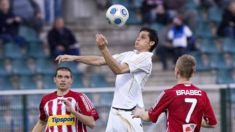 Fotbalista Dukly Praha Pavel Vrána proniká mezi Michalem Vepekem (vlevo) a Jakubem Brabcem.  