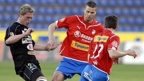 Příbramský záložník Tomáš Borek se snaží prostrčit míč mezi dvěma hráči Plzně.