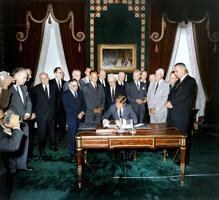 John Fitzgerald Kennedy podepisuje smlouvu v roce 1963 v Bílém Dom v USA.