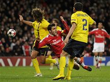KLOV MOMENT. Cesc Fabregas z Arsenalu se kc k zemi a nsleduje erven karta pro obrnce Carlese Puyola a pedevm penalta proti Barcelon. 
