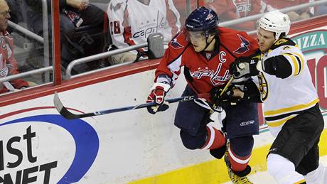 Kapitán Washingtonu Alexandr Ove�kin se �ene za pukem, brání ho Dennis Wideman z Bostonu.