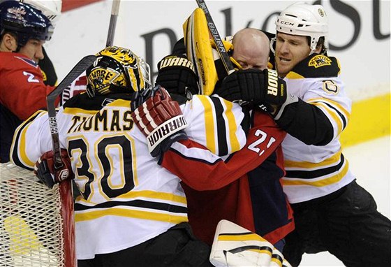 Gólman Bostonu Bruins Tim Thomas (30) a jeho spoluhrá Dennis Wideman ve rvace s Jason Chimerou z Washingtonu Capitals