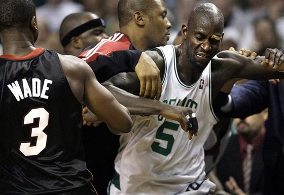 STRKANICE V NBA: Kevin Garnett (vpravo) z Bostonu Celtics se sápe na Quentina Richardsona (mimo zábr) z Miami Heat. Pihlíí i hvzda Miami Dwyane Wade