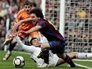 Lionel Messi, útoník Barcelony (v popedí), bojuje o mí s Raulem Albiolem z Realu Madrid