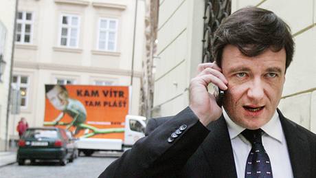 David Rath p�ichází do Poslanecké sn�movny, za ním projí�dí auto s p�edvolebním billboardem, na kterém je st�edo�eský hejtman vyobrazen jako chameleon. (15. dubna 2010)