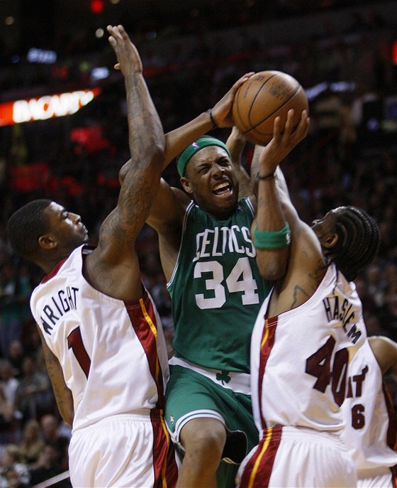 Paul Pierce z Bostonu (uprosted) se probíjí mezi bránícími hrái Miami Dorell Wrightem (vlevo) a  Udonisem Haslemem. 