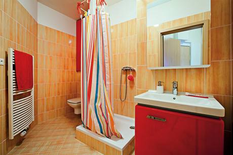 Prostorn koupeln dominuje erven barva a vysok lesk originln retro kolekce nbytku Star 