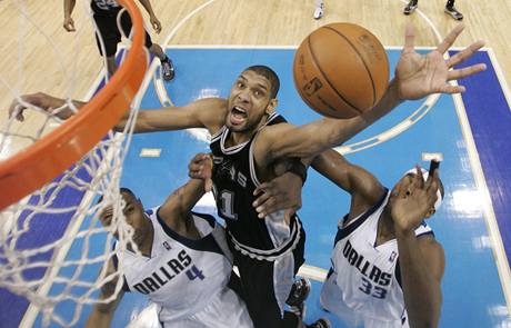 Tim Duncan (vlevo) ze San Antonia Spurs zskv doskok v souboji s pivoty Dallasu Mavericks