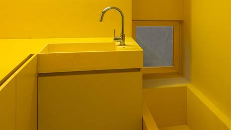 Stny v koupeln jsou vymalovány omyvatelnou barvou ve lutém odstínu. Vana je z moderního materiálu Corian 
