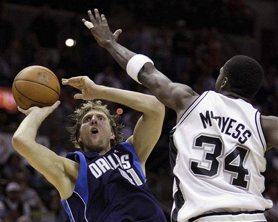 Dirk Nowitzki (vlevo) z Dallasu Mavericks zakonuje pes Antonia McDyesse ze San Antonia Spurs