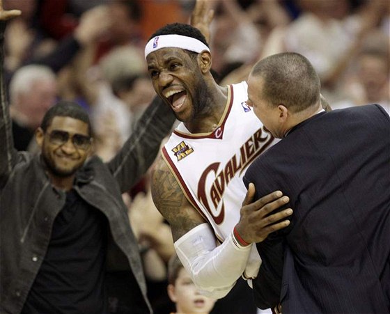 LeBron James (uprosted) z Clevelandu Cavaliers objímá Michaela Malonea, asistenta trenéra. Vlevo rapper Usher, spolumajitel klubu.