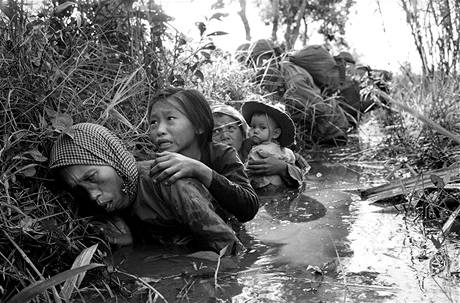 Vietnamsk eny a dti se v lednu 1966 kr v bahnitm kanlu pobl Bao Trai, schovvaj se ped tkou palbou Vietkongu.