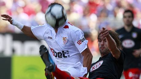 MÍSTO HLAVY MÍ má Adriano Correia, hrá Sevilly. V souboji s ním je Juan Varela z Atlétika Madrid.