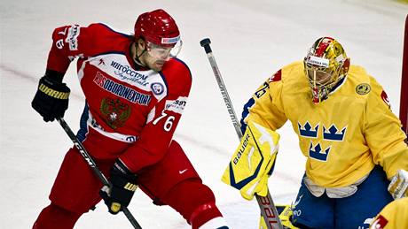 Ruský hokejista Jevgenij Artjuchin se snaží zasáhnout puk před brankou švédského gólmana Jakoba Markströma.