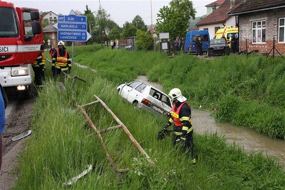 Auto skonilo v potoce stechou dol, obyvatelm Bohuslavic se podailo zachránit posádku a otoit jej na bok. (14. kvtna 2010)