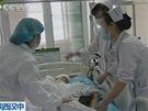 Lékai oetují jedno z dtí, které zranil útoník ve kolce v provincii an-si. (12. kvtna 2010)