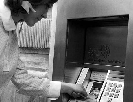 Rok 1968. Dívka v centru Londýna vybírá peníze z  jednoho z prvních bankomat.