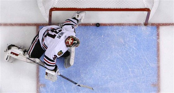 Branká Antti Niemi z Chicaga Blackhawks inkasuje rozhodující gól z hole Clauda Girouxe.