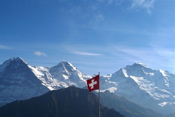výcarsko. Pohled na trio Eiger, Monch, Jungfrau ze Schynigge Platte (za vlajkou observato Sphinx)