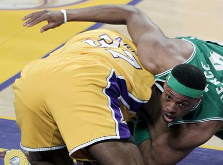 Ron Artest (ve lutm) z LA Lakers svd souboj o m s Paulem Piercem z Bostonu Celtics