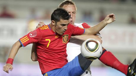 �pan�lská hv�zda David Villa (vlevo) v souboji s polským fotbalistou Kamilem Glikem.