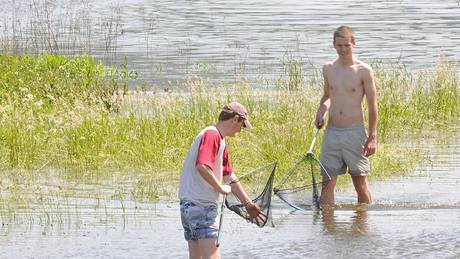 V zatopených lagunách nedaleko Uheric mladíci loví uvízlé ryby.