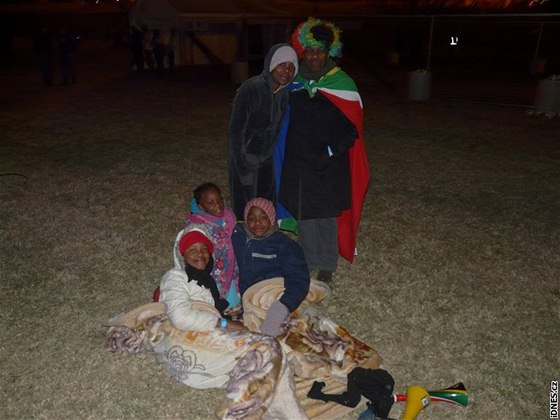Rodina ve fanzón pi zápase Jiní Afrika - Uruguay. Nejmení se zimou schovávají do deky.
