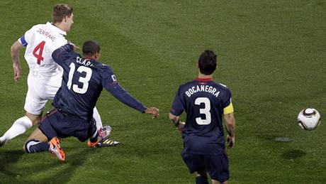 GÓLOVÁ STELA Anglický záloník Steven Gerrard (vlevo) stílí pes amerického soupee Clarka úvodní gól zápasu.