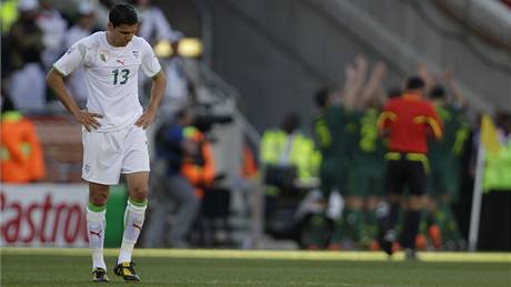 Alžírský fotbalista Matmúr smutní po slovinském gólu.