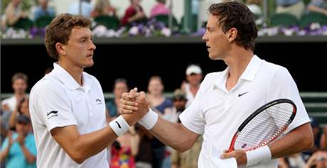 BITVA. Tenisté Denis Istomin (vlevo) a Tomá Berdych si podávájí ruce po dlouhém vzájemném zápase ve Wimbledonu.