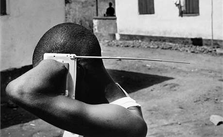 Muž s useknutými končetinami poslouchá rádio v táboře pro oběti občanské války ve Freetownu v Sierra Leone. (listopad 2005)
