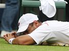 Alejandro Falla se nechává oetovat bhem zápasu s Rogerem Federerem ve Wimbledonu.