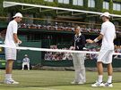 PED ZÁPASEM. Ped utkáním ve Wimbledonu se zdraví s rozhodí John Isner (vlevo) a Thiemo De Bakker.