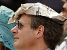 KLOBOUK. Fanouek v tenisovém Wimbledonu je vynalézavý, místo klobouku pouil noviny.