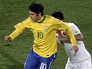 KOMU PIHRÁT? Brazilec Kaká si kryje mí ped dotírajícím chilským fotbalistou.