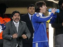 POKYNY. Argentinsk tonk Messi (vpravo) se oberstvuje, zatmco mu trenr Maradona udl pokyny.