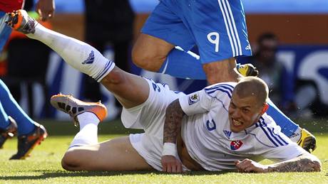 NA ZEMI. Slovenský stoper Martin �kr�el padá na trávník v zápase s Paraguayí.